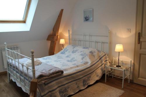 a bedroom with a bed and two lamps and a window at Gîte La Briqueterie 3 Épis in Quesnoy-le-Montant