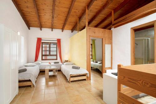 a living room with two beds and a couch at Casa Las Flores in Moya