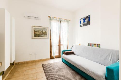 a living room with a blue couch and a window at Casa Rimedia in Solanas