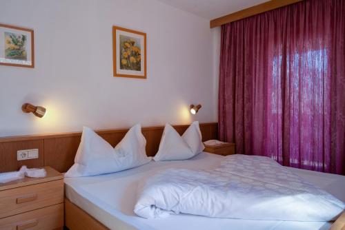 a bedroom with a white bed with a purple curtain at Apartment 6 - Zur Sonne in Laion