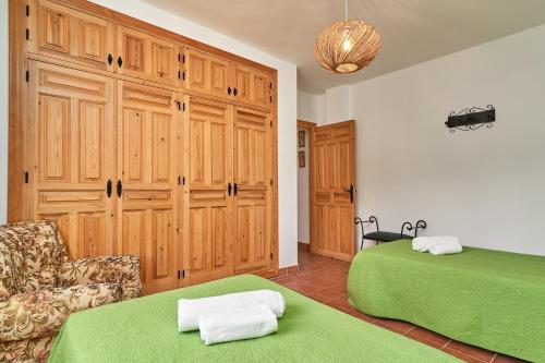 a bedroom with two beds and a couch and a chair at Cortijo Los Ángeles Morea in Frigiliana