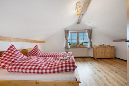 a bedroom with a bed with red and white pillows at Ferienwohnung am Teisenberg in Teisendorf