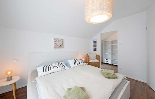 a white bedroom with a bed and a table at Ferienhaus Moos in Wasserburg