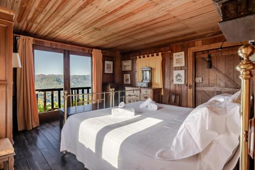 a bedroom with a bed and a large window at Casa do Gerês in Geres