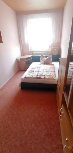 a small bedroom with a bed and a window at Ferienwohnung Mücheln 1 in Mücheln