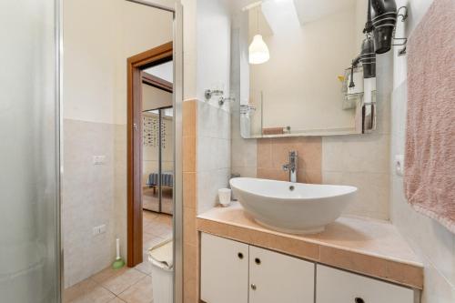 a bathroom with a white sink and a mirror at Casa Susanna in Calasetta