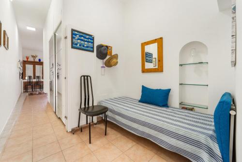 a small bedroom with a bed and a chair at Casa Susanna in Calasetta