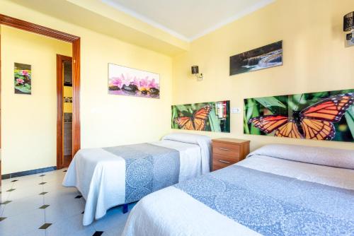 a room with three beds with butterflies on the walls at 50 mts beach with sea views pool in Algarrobo-Costa