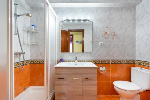a bathroom with a toilet and a sink and a mirror at 50 mts beach with sea views pool in Algarrobo-Costa