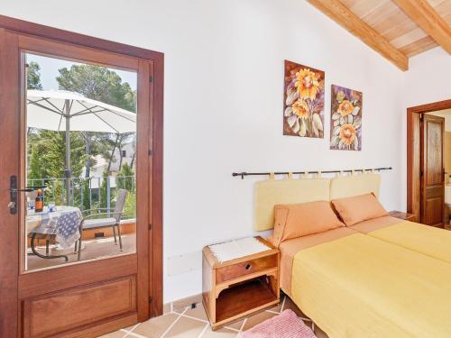 a bedroom with a bed and a balcony with a table at Es Romaní in Cala Ratjada