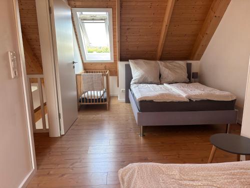 a small bedroom with a bed in a attic at Gut Bennewohld in Heide