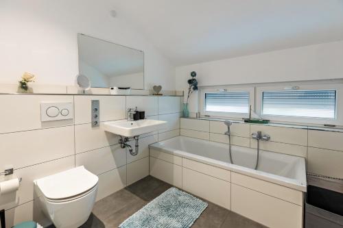 a bathroom with a tub and a sink and a toilet at Schmuckstück in Hilzingen