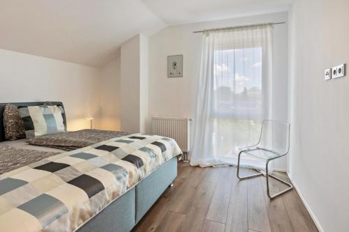 a bedroom with a bed and a chair and a window at Schmuckstück in Hilzingen