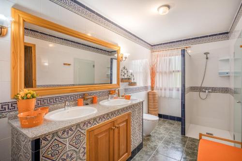 a bathroom with two sinks and a toilet and a mirror at Ca na Rossa in Campanet