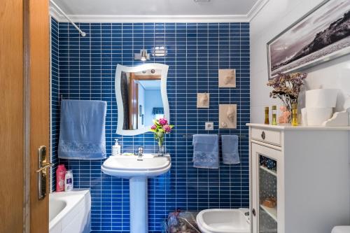a blue tiled bathroom with a sink and a mirror at El Rincón de Agüero in Agüero