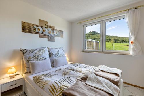 a white bedroom with a bed and a window at Apartment Ayleen in Boll