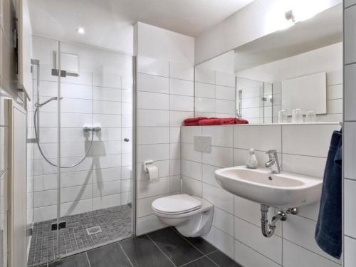 a white bathroom with a toilet and a sink at Hochburger 21 in Emmendingen