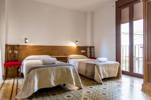 a room with two beds and a balcony at Pio in Tremp