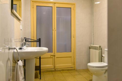 a bathroom with a sink and a toilet and a yellow door at Pio in Tremp