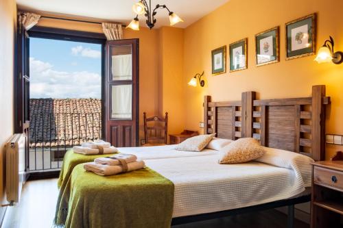 a bedroom with two beds and a large window at Las Puentes 1 in Candelario