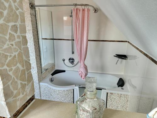 a bathroom with a bath tub and a glass vase at Anker Perla in Grömitz