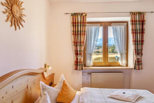 a bedroom with a bed and a window at Alpenblick Tilly - Fewo Lautersee 3 in Krün