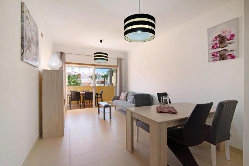 a dining room and living room with a table and chairs at Royal Cabanas Golf 89 in Cabanas de Tavira