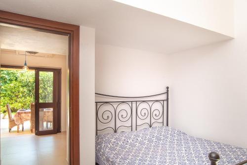 a bedroom with a bed and a door to a patio at Vecchio Marino H4 in Palau