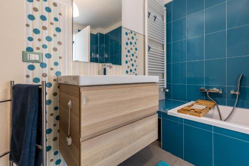 a bathroom with blue tiles and a sink and a tub at La Casa In Collina Con Vista in Grezzana