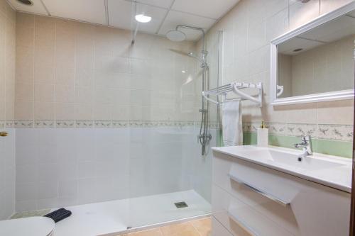 a white bathroom with a sink and a shower at Saadia Golf in Huelva