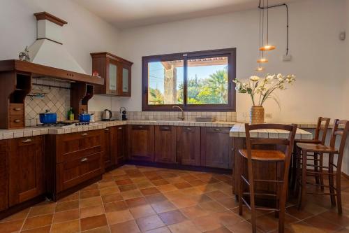 a kitchen with wooden cabinets and a large window at Villa Stella in Marsala
