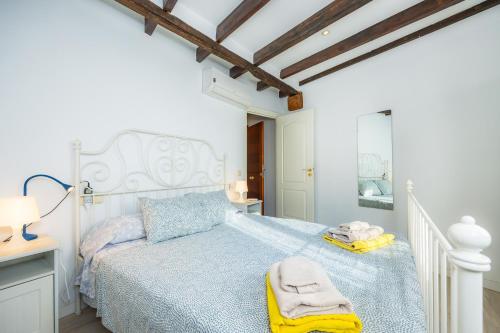 a bedroom with a white bed with a blue comforter at Apartamento Can Roses in Moscari