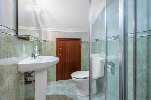 a bathroom with a toilet and a sink and a shower at Quintanal de Villacarriedo in Villacarriedo