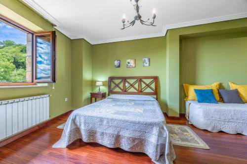 a green bedroom with two beds and a window at Quintanal de Villacarriedo in Villacarriedo