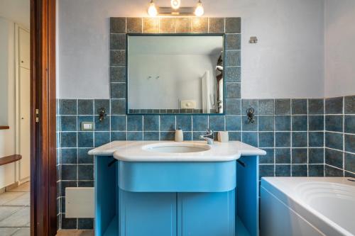 a blue bathroom with a sink and a mirror at villa Isabel 2 in Villasimius