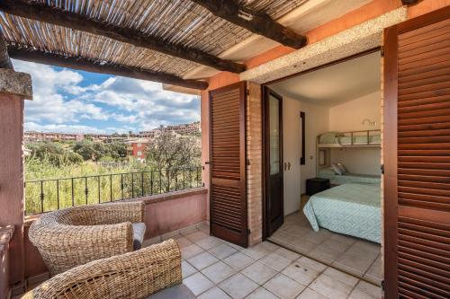 a room with a balcony with a bed and a bedroom at villa Isabel 2 in Villasimius