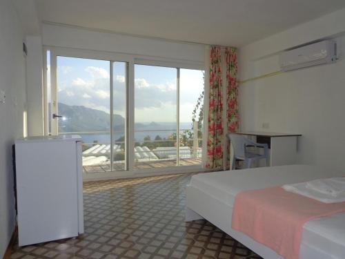 a hotel room with a bed and a large window at çiftlik tepesi pansiyon in Kumluca