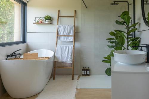 a bathroom with a white tub and a sink at Casa Muxía Mar y montaña in Muxia