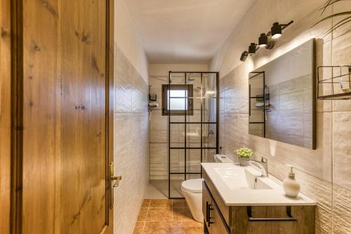 a bathroom with a sink and a toilet and a mirror at Can Planas 1 in Fonolleras