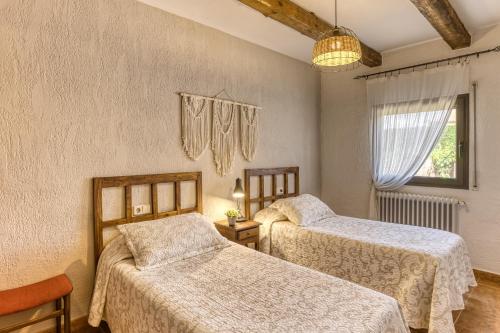 a bedroom with two beds and a window at Can Planas 1 in Fonolleras