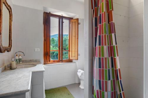 a bathroom with a shower with a colorful shower curtain at Tuscany Charme Coselli Restored in Capannori