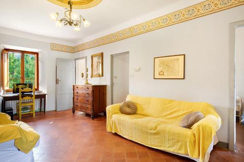 a living room with a yellow couch and a table at Tuscany Charme Coselli Restored in Capannori