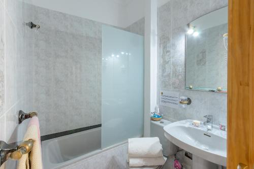 a bathroom with a sink and a tub and a toilet at El Golfo Lanzarote in El Golfo
