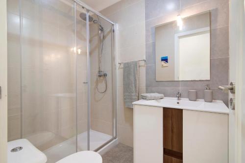 a bathroom with a shower and a sink and a toilet at Telmus Villa Rc in Monte Gordo