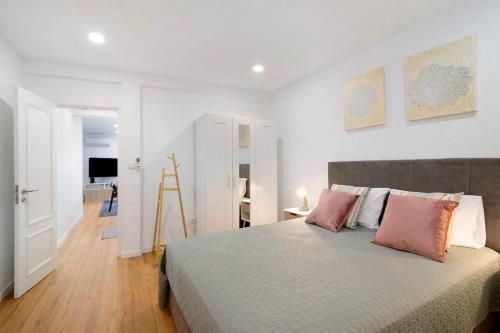 a bedroom with a large bed with pink pillows at Telmus Villa Rc in Monte Gordo