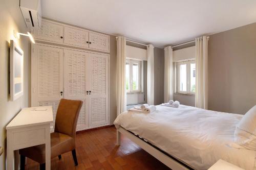 a bedroom with a bed and a desk and a chair at Villa Apfel in Vale do Lobo