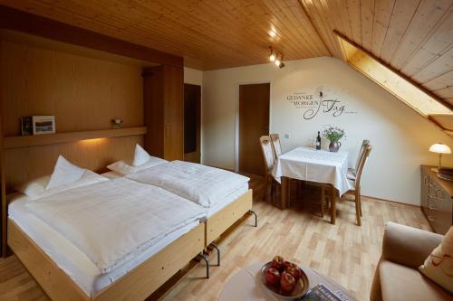 a bedroom with a large bed and a table at Haus Am Kaltenbach in Enzklösterle