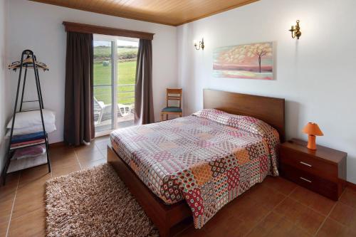 a bedroom with a bed and a window at Casa Do Monte in Achadinha