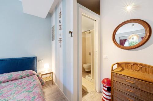 a bedroom with a bed and a mirror on the wall at Goccia di mare with free parking in Levanto