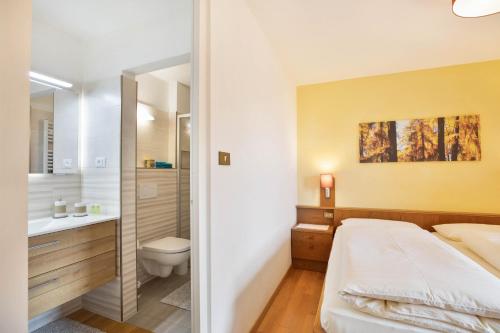 a bathroom with a bed and a toilet and a sink at Appartements Gabrielli Anna in Trodena